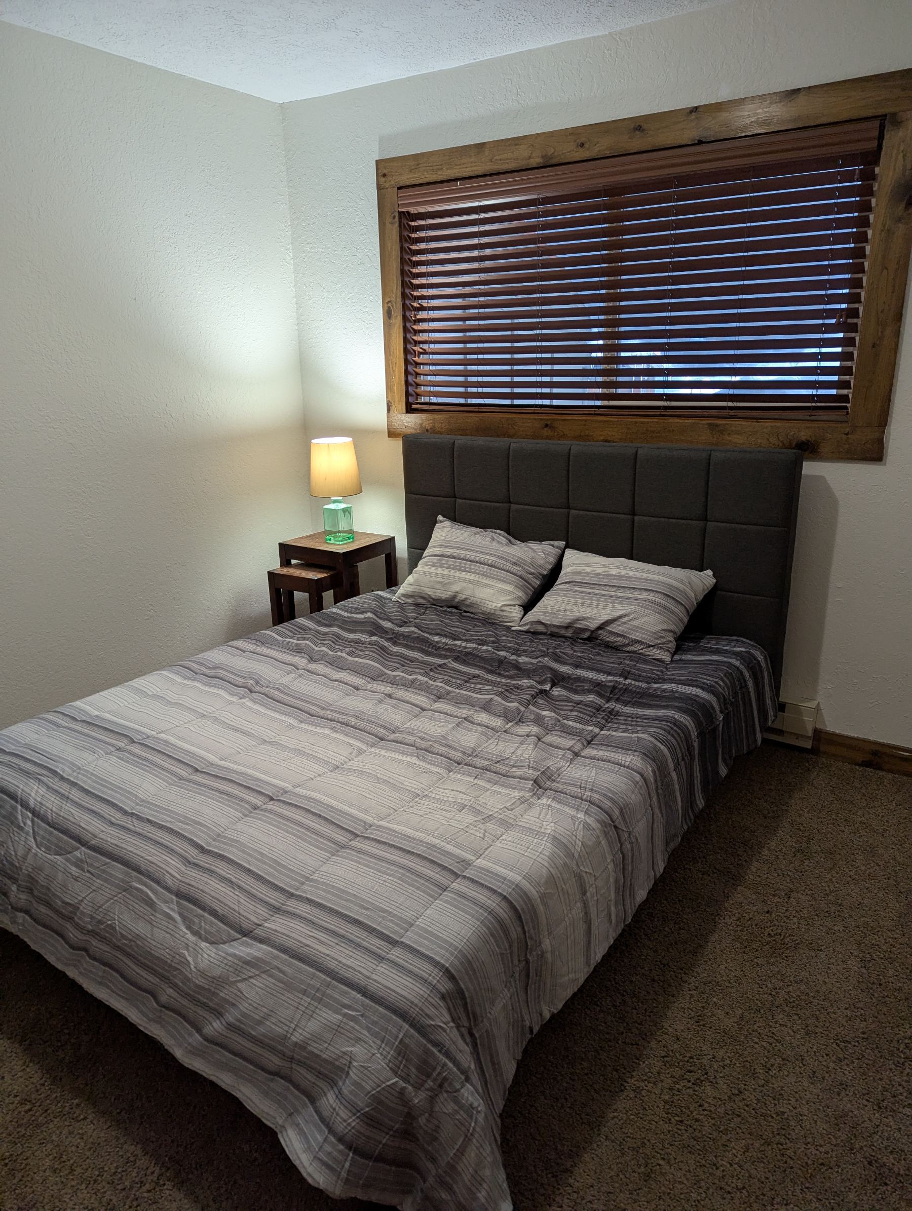 Queen bed with grey upholstered headboard