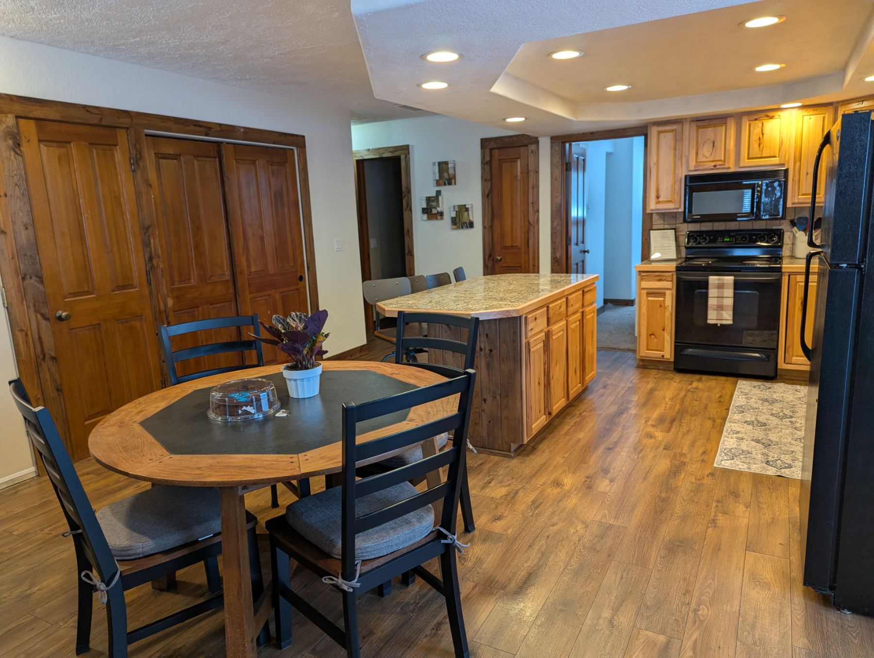 Round dining table for four with kitchen island behind