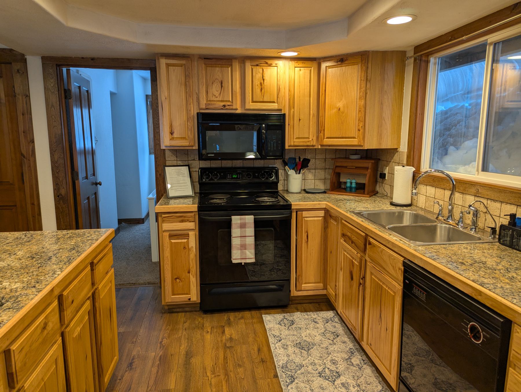 Kitchen with hickory cabinets, electric range, and granite counters