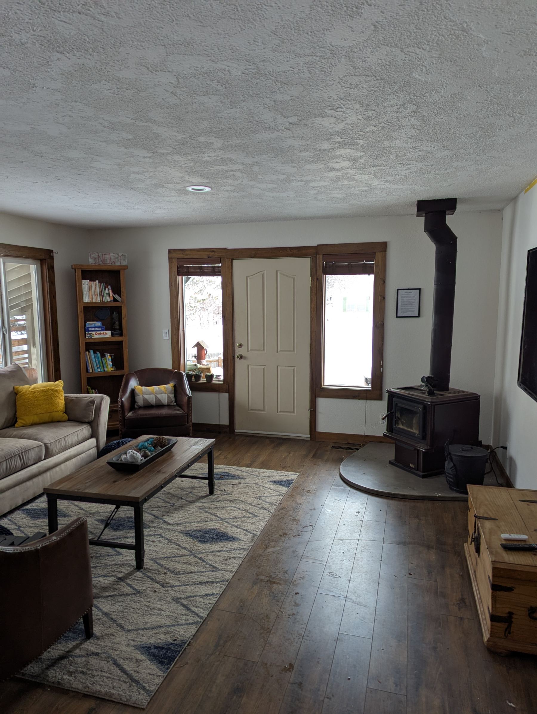 Living room with wood stove and bookshelf in daylight